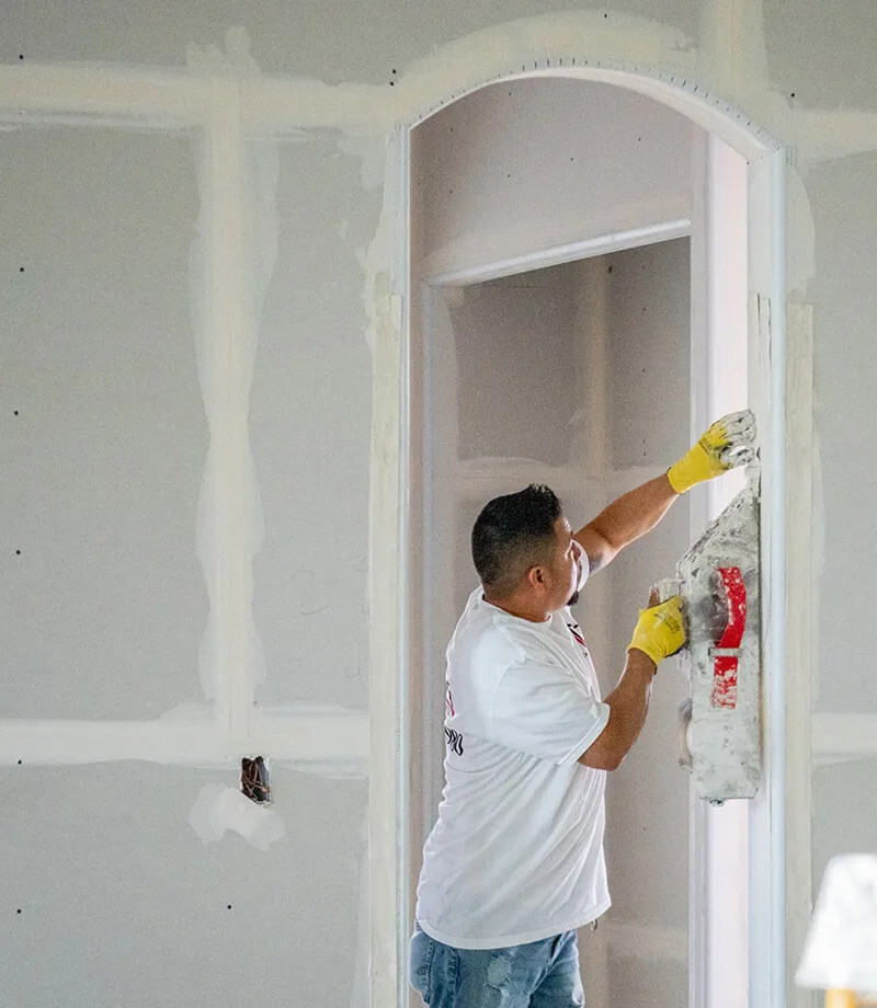 Finishing Arch Worker taping drywall around arch